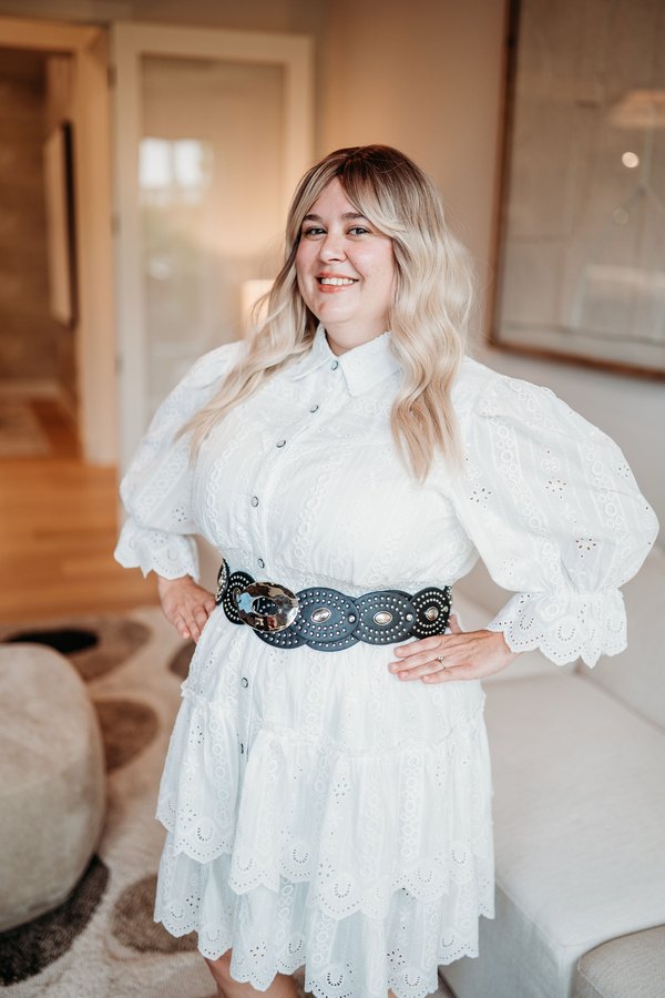 Kimberly Edwards, smiling, in a white eyelet dress